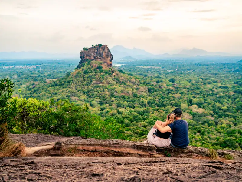 Couple s'enlaçant face au Rocher du Lion au Sri Lanka Pidurangala Voyage Romantique