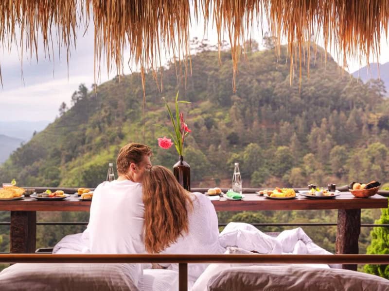 Couple se câlinant face à une vue spectaculaire sur les montagnes et plantations de thé au Sri Lanka