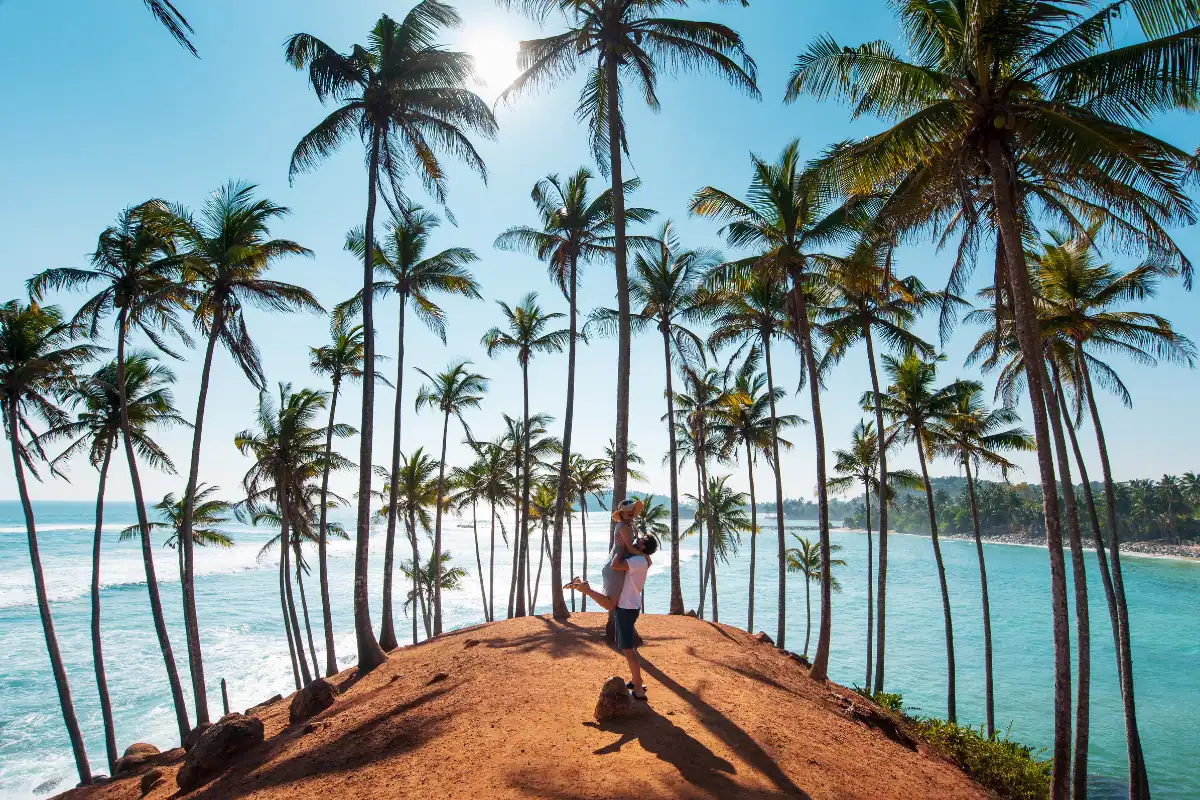 Couple se sautant dans les bras sur une île bordée de palmiers au Sri Lanka