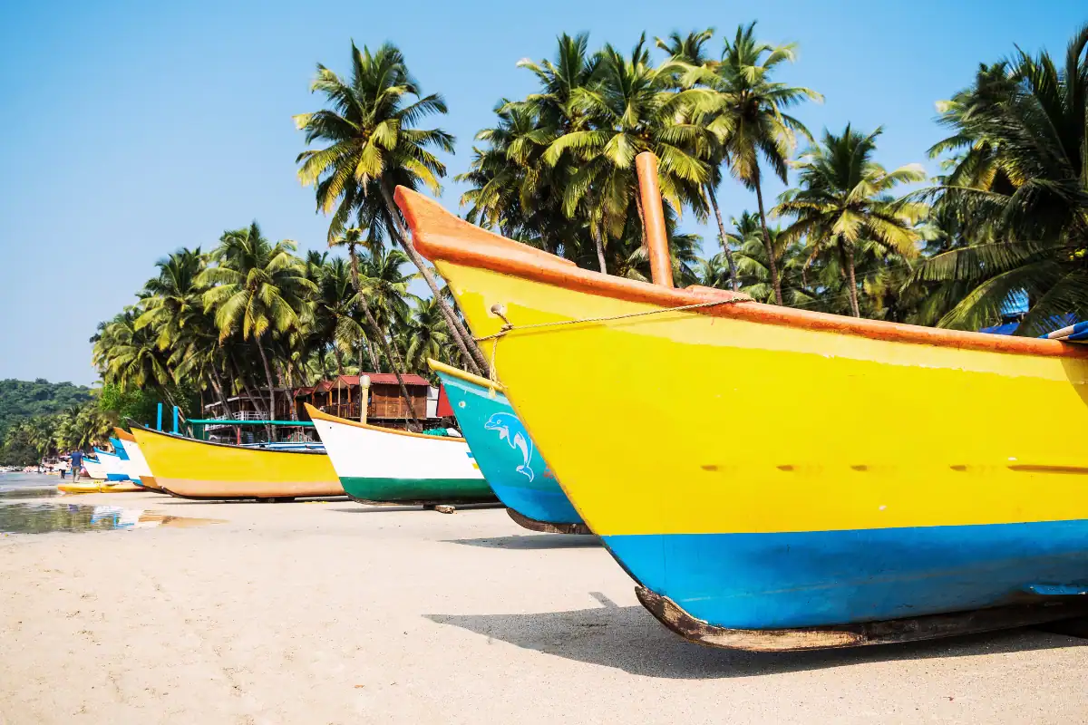 Barques colorées sur une superbe plage au sable blanc bordée de palmiers en Inde