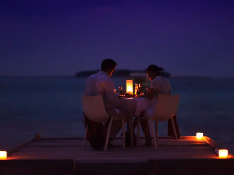 Couple assis en train d'observer la vue lors d'un diner romantique à la plage au Sri Lanka