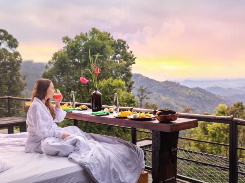 Couple prenant un petit dejeuner romantique au Sri Lanka face à une vue sur un panorama de montagnes verdoyantes