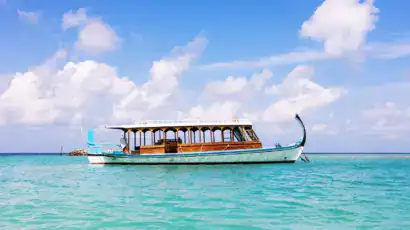 Dhoni Bateau traditionnel des Maldives navigant sur des eaux turquoises et translucides