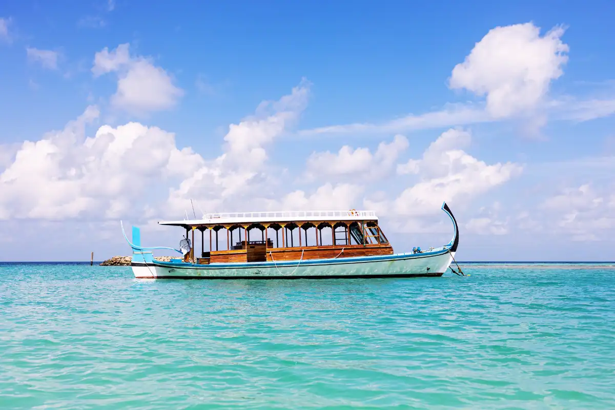 Dhoni Bateau traditionnel des Maldives navigant sur des eaux turquoises et translucides