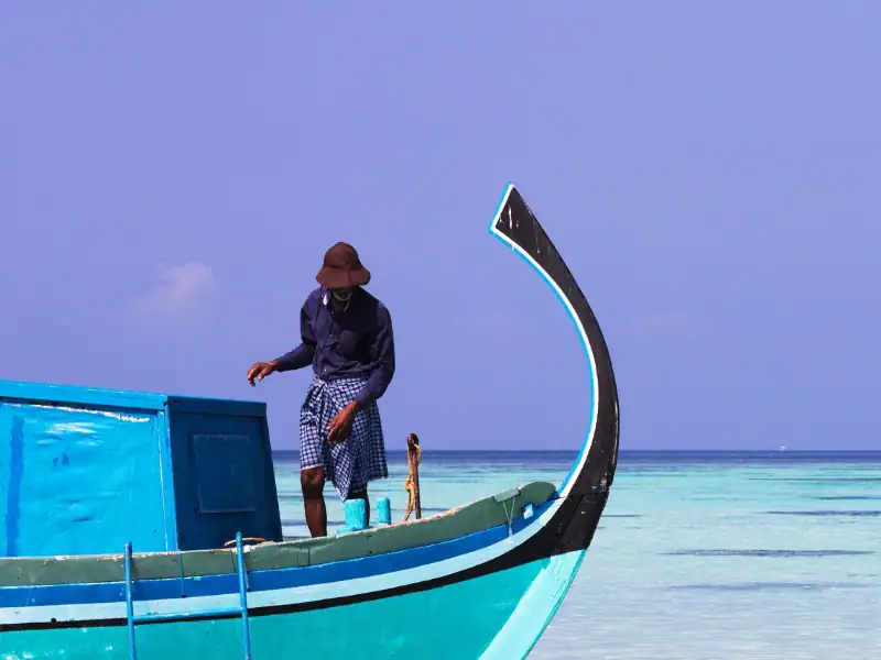 Activité authentique de pêche aux Maldives sur bateau bleu dans une mer turquoise avec pêcheur local