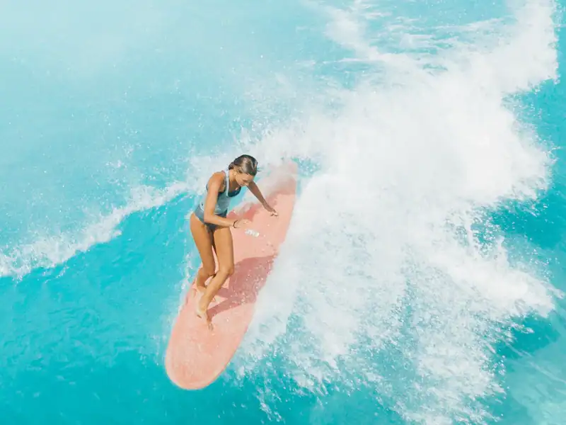 Fille surfant sur les eaux turquoises des Maldives