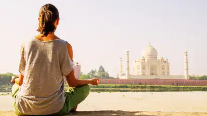 Femme faisan de la méditation face au Taj Mahal en Inde lors d'un séjour bien être