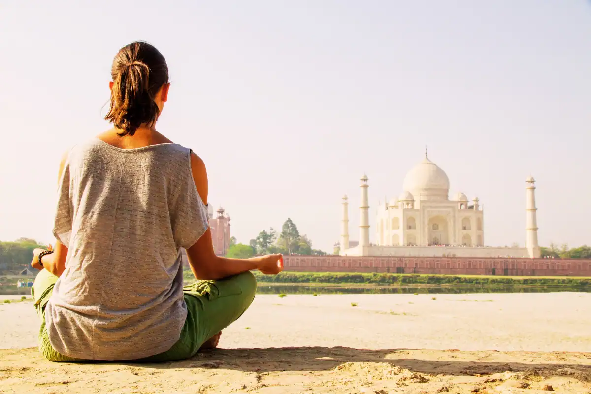 Femme faisan de la méditation face au Taj Mahal en Inde lors d'un séjour bien être